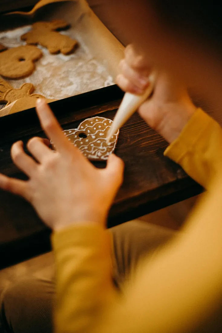 Close-up of gingerbread cookie decoration with icing for festive holiday preparation.